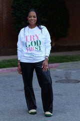 Model wearing the Try God First Deuteronomy 31:6 pink and green crewneck